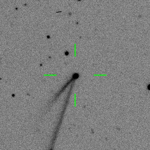 Gray-scale image of a space object with a tail, marked by green crosshairs, suggesting a comet against a background of stars.